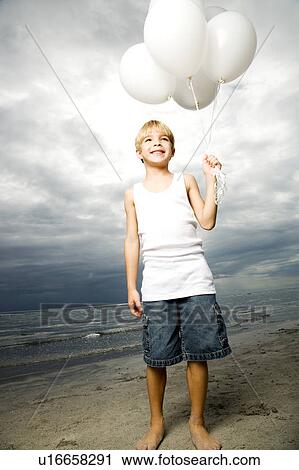 A young boy with a bunch of balloons View Large Photo Image Stock Image - A young boy with a bunch of balloons. Fotosearch