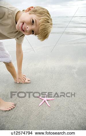 A young boy with a starfish View Large Photo Image Picture - A young boy with a starfish. Fotosearch