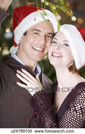 A couple kissing beneath the mistletoe View Large Photo Image Stock Photography - A couple kissing beneath the mistletoe. Fotosearch