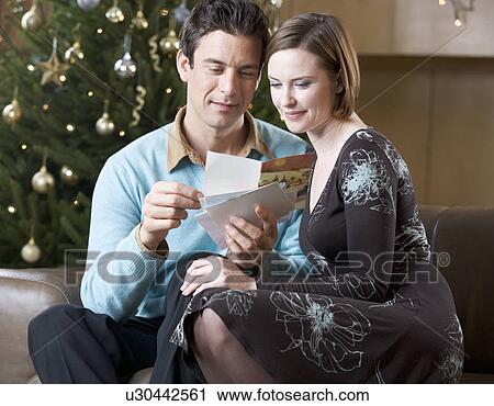 A couple reading Christmas cards View Large Photo Image Stock Image - A couple reading Christmas cards. Fotosearch