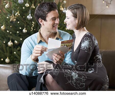 A couple reading Christmas cards View Large Photo Image Stock Photograph - A couple reading Christmas cards. Fotosearch