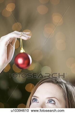 A woman holding a Christmas decoration View Large Photo Image Stock Image - A woman holding a Christmas decoration. Fotosearch