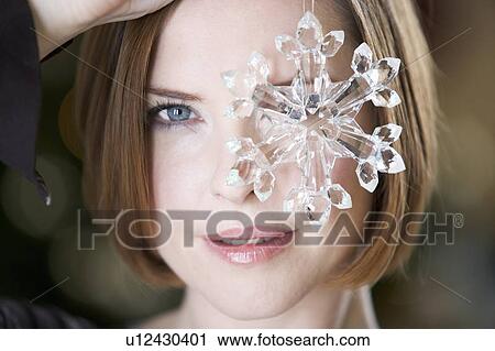 A woman holding a Christmas decoration View Large Photo Image Stock Image - A woman holding a Christmas decoration. Fotosearch