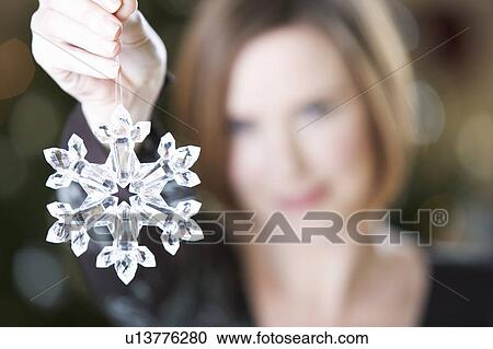 A woman holding a Christmas decoration View Large Photo Image Stock Image - A woman holding a Christmas decoration. Fotosearch