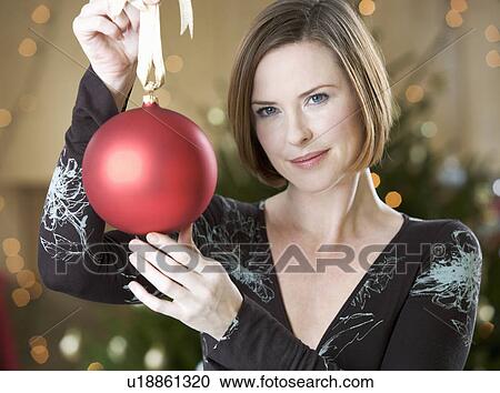 A woman holding a Christmas decoration View Large Photo Image Stock Image - A woman holding a Christmas decoration. Fotosearch