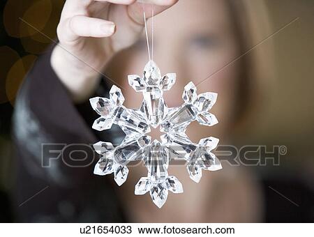 A woman holding a Christmas decoration View Large Photo Image Stock Image - A woman holding a Christmas decoration. Fotosearch