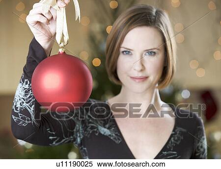 A woman holding a Christmas decoration View Large Photo Image Stock Photography - A woman holding a Christmas decoration. Fotosearch