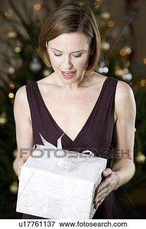 A woman holding a present View Large Photo Image Stock Photo - A woman holding a present. Fotosearch