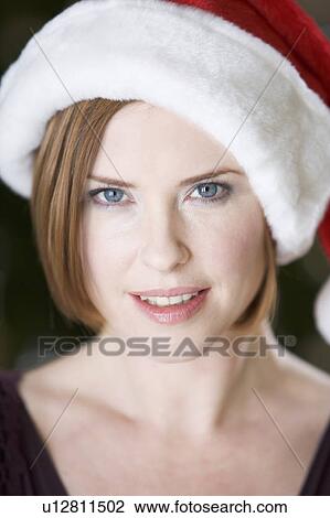 Portrait of a woman wearing Santa's hat View Large Photo Image Stock Image - Portrait of a woman wearing Santa's hat. Fotosearch