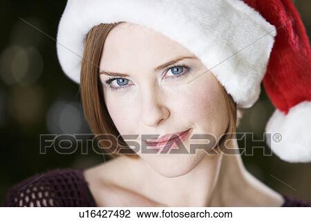 Portrait of a woman wearing Santa's hat View Large Photo Image Stock Image - Portrait of a woman wearing Santa's hat. Fotosearch