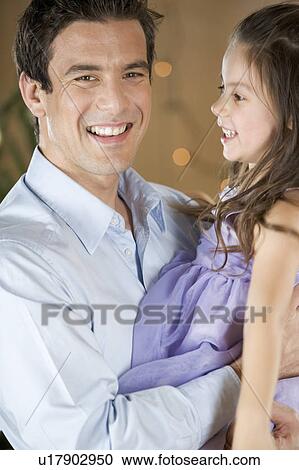 Stock Image - A father holding his young daughter. Fotosearch