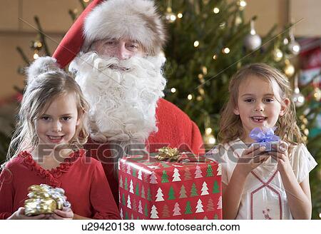 A grandfather dressed as Santa Claus with his grandchildren View Large Photo Image Stock Photo - A grandfather dressed as Santa Claus with his grandchildren. Fotosearch