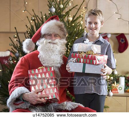 Stock Photography - A grandfather dressed as Santa Claus with his grandson. Fotosearch