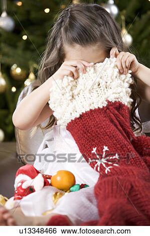 A young girl delving into a Christmas stocking View Large Photo Image Stock Photograph - A young girl delving into a Christmas stocking. Fotosearch