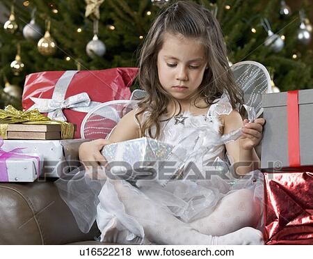 A young girl dressed as a fairy opening a Christmas present View Large Photo Image Stock Photo - A young girl dressed as a fairy opening a Christmas present. Fotosearch