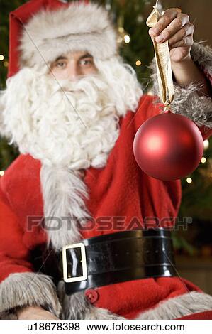 Father Christmas or Santa Claus holding a bauble View Large Photo Image Stock Photo - Father Christmas or Santa Claus holding a bauble. Fotosearch