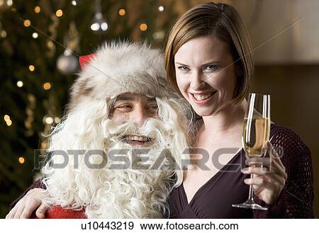 Stock Photo - Father christmas / santa Claus and a woman drinking champagne. Fotosearch