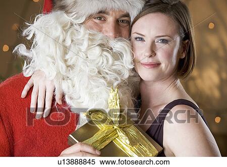 Father christmas / santa Claus giving a present to a mother View Large Photo Image Stock Photography - Father christmas / santa Claus giving a present to a mother. Fotosearch