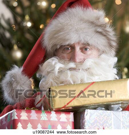 Father christmas / santa Claus holding a pile of presents View Large Photo Image Picture - Father christmas / santa Claus holding a pile of presents. Fotosearch