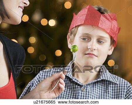 A boy refusing to eat a Brussels sprout View Large Photo Image Stock Photography - A boy refusing to eat a Brussels sprout. Fotosearch