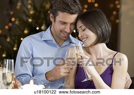 A couple celebrating Christmas with a glass of champagne View Large Photo Image Stock Image - A couple celebrating Christmas with a glass of champagne. Fotosearch