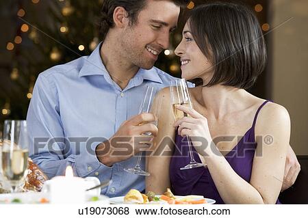 A couple celebrating Christmas with a glass of champagne View Large Photo Image Stock Photo - A couple celebrating Christmas with a glass of champagne. Fotosearch