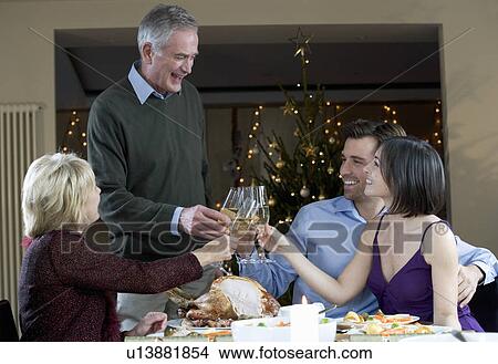 A family celebrating Christmas with a glass of champagne View Large Photo Image Picture - A family celebrating Christmas with a glass of champagne. Fotosearch