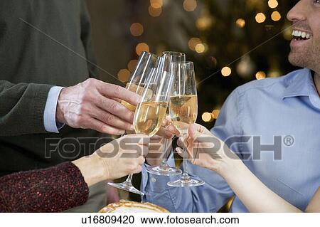 A family celebrating Christmas with a glass of champagne View Large Photo Image Stock Image - A family celebrating Christmas with a glass of champagne. Fotosearch