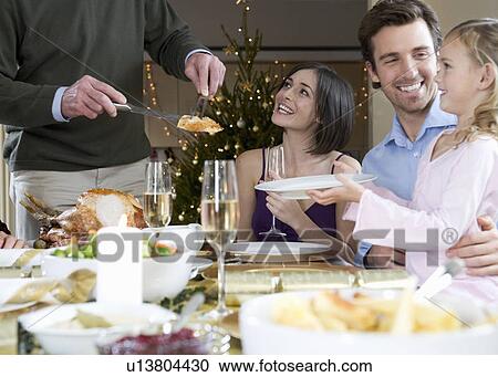 A family sitting down for Christmas dinner View Large Photo Image Stock Image - A family sitting down for Christmas dinner. Fotosearch