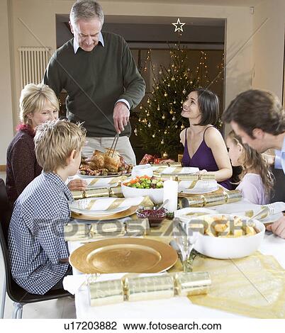 Stock Image - A family sitting down for Christmas dinner. Fotosearch