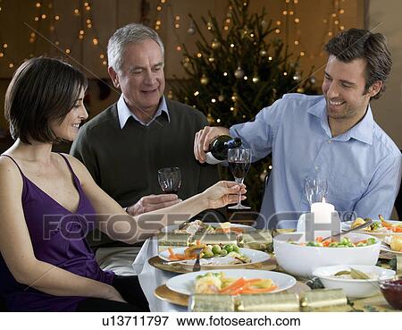 A family sitting down for Christmas dinner View Large Photo Image Stock Photo - A family sitting down for Christmas dinner. Fotosearch