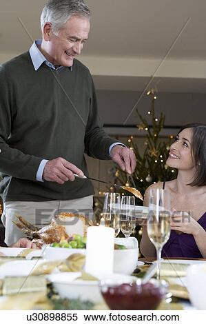 A father serving Christmas dinner to his daughter View Large Photo Image Stock Photography - A father serving Christmas dinner to his daughter. Fotosearch