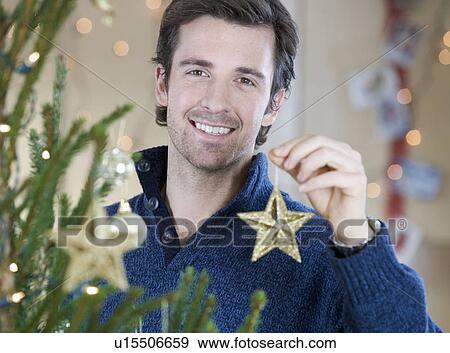 A man decorating the Christmas tree View Large Photo Image Stock Photo - A man decorating the Christmas tree. Fotosearch