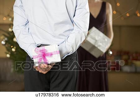 A man holding a surprise gift View Large Photo Image Stock Photograph - A man holding a surprise gift. Fotosearch