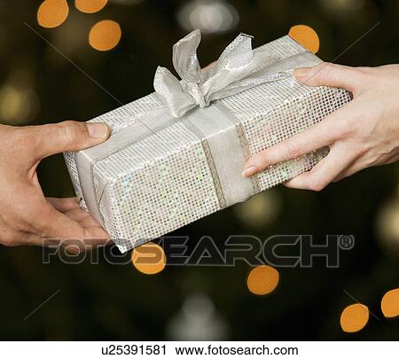 A present being exchanged View Large Photo Image Stock Image - A present being exchanged. Fotosearch