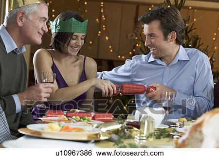 Pulling Christmas crackers View Large Photo Image Stock Photograph - Pulling Christmas crackers. Fotosearch