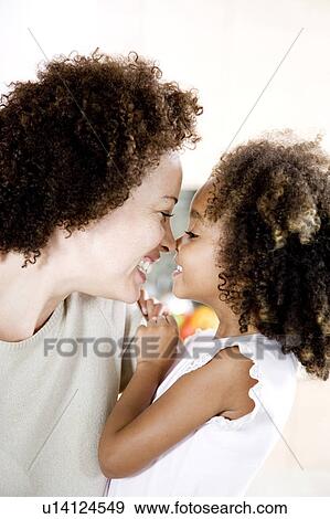 Stock Photo - Happy mother and daughter touching noses. Fotosearch