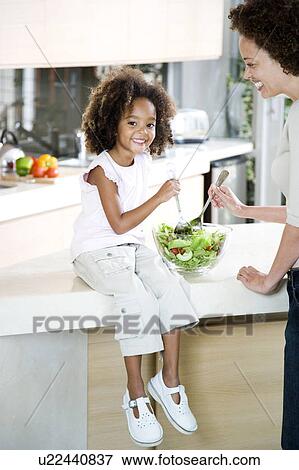 Mother and young daughter making salad for lunch in the kitchen View Large Photo Image Stock Photo - Mother and young daughter making salad for lunch in the kitchen. Fotosearch