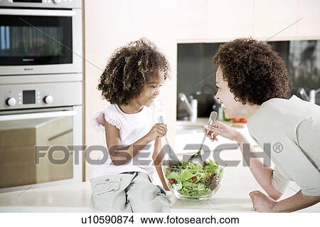 Mother and young daughter preparing healthy salad lunch together View Large Photo Image Picture - Mother and young daughter preparing healthy salad lunch together. Fotosearch