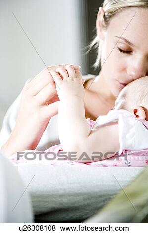 Stock Photo - Mother kissing baby girl. Fotosearch