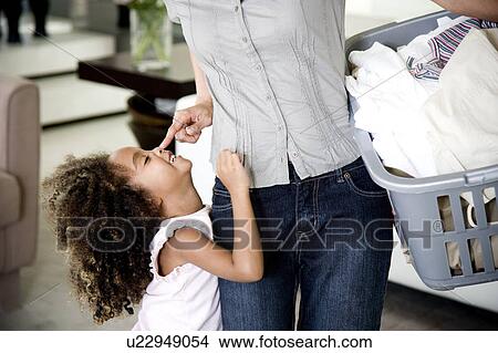 Mother playing with young daughter, carrying the washing View Large Photo Image Picture - Mother playing with young daughter, carrying the washing. Fotosearch