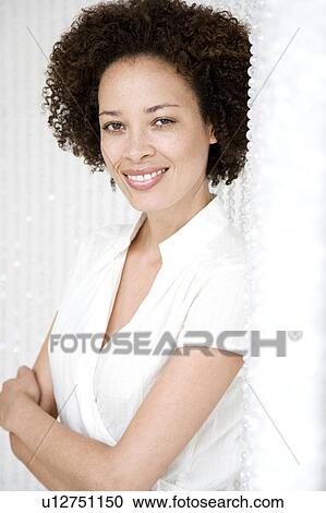 Portrait of confident woman smiling, arms folded and wearing a white top View Large Photo Image Stock Image - Portrait of confident woman smiling, arms folded and wearing a white top. Fotosearch