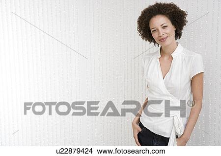 Picture - Portrait of stylish and confident woman in a white wraparound top. Fotosearch