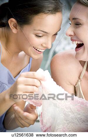 Two women sitting outside laughing at sexy underwear they've just purchased View Large Photo Image Stock Photo - Two women sitting outside laughing at sexy underwear they've just purchased. Fotosearch