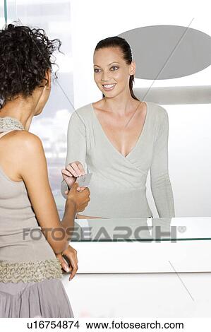 Woman handing credit card to the sales assistant in a store View Large Photo Image Picture - Woman handing credit card to the sales assistant in a store. Fotosearch