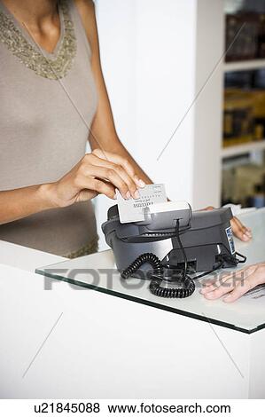 Stock Photo - Woman paying by credit card in a store. Fotosearch