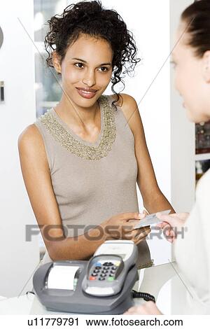 Woman paying for goods by credit card View Large Photo Image Stock Image - Woman paying for goods by credit card. Fotosearch