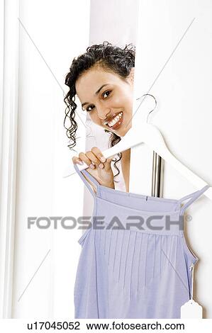 Woman trying on a sun top in the changing room of a shop View Large Photo Image Stock Image - Woman trying on a sun top in the changing room of a shop. Fotosearch