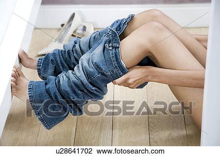 Woman trying on jeans in the changing room of a shop View Large Photo Image Stock Image - Woman trying on jeans in the changing room of a shop. Fotosearch