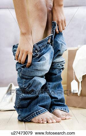 Woman trying on jeans in the changing room of a shop View Large Photo Image Stock Photo - Woman trying on jeans in the changing room of a shop. Fotosearch